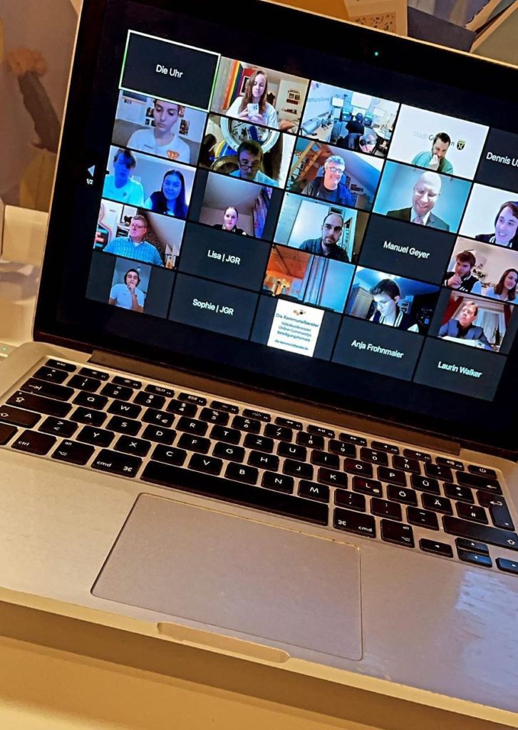 Laptop mit geöffneter Zoom-Konferenz. Die Teilnehmenden sind in kleinen Kacheln abgebildet